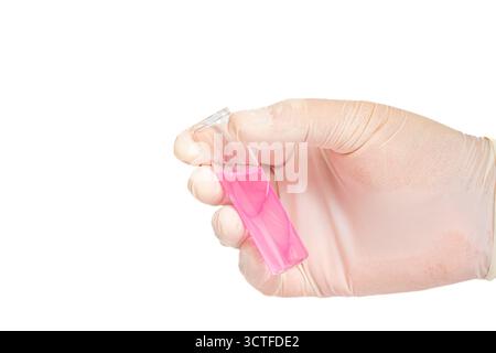 Gloved hand holding test tube with pink liquid on isolated white background. Close up of gloved hand with pink filled glass test tube Stock Photo