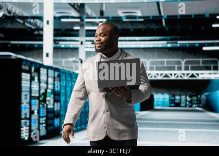Technician in data center workspace running system diagnostic tests, monitoring performance. Employee looking for network issues affecting rigs performance, upgrading enterprise networks hardware Stock Photo