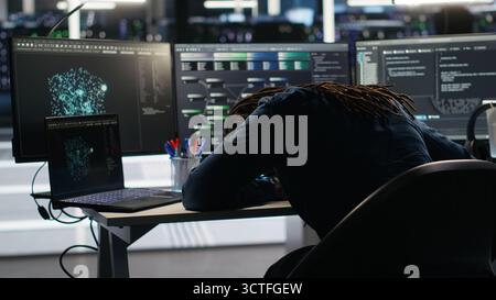 Irked data center admin raging because of malfunctioning node tree software analyzing datasets. Irascible server hub worker exasperated by visual programming tools not improving performance, camera B Stock Photo