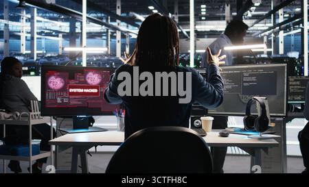 Panicked engineer in AI server facility reacts to hacking incident involving theft of sensitive data. Data center employee alarmed by computer virus triggered by security systems, camera A Stock Photo