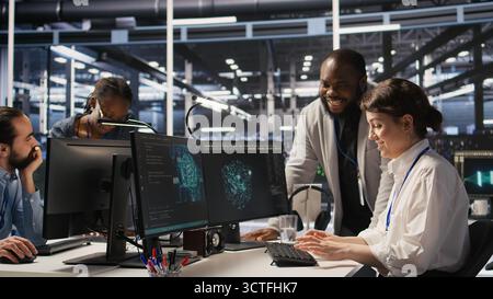 Joyous data center team leader giving high five to worker after successful infrastructure upgrade. Pleased coworkers celebrating collaborative achievement during AI systems deployment, camera A Stock Photo