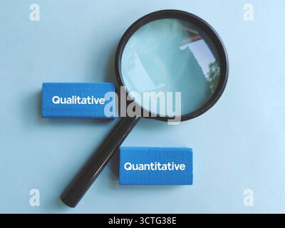 Magnifying Glass Focusing on Qualitative and Quantitative Text Blocks Representing Research Methods and Data Analysis Stock Photo