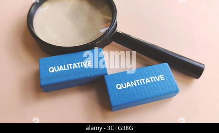 Magnifying Glass Focusing on Qualitative and Quantitative Text Blocks Representing Research Methods and Data Analysis Stock Photo