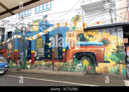 mural on E. Jacinto Street in Baguio City, Philippines, for Salimisim: Culture and Arts Festival,  person with a basket on a truck, large sunflowers Stock Photo
