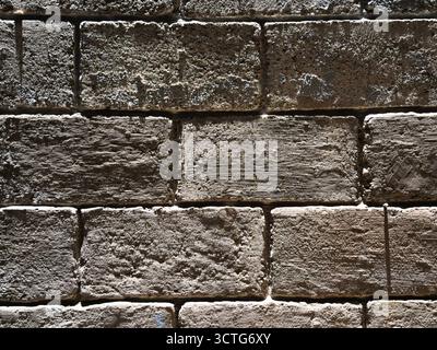 Detail of an old textured brick wall with a rough and weathered surface Stock Photo