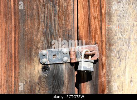 Old lock on a rustic abandoned wooden building Stock Photo