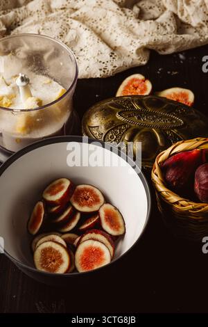 Rustic still life photography featuring a homemade fig galette on parchment paper. This gourmet dessert is captured in a low key light setting on a da Stock Photo