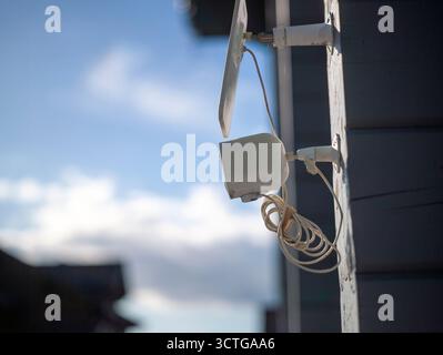a surveillance camera powered by a solar panel and mounted on the wall Stock Photo