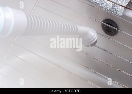 Steam cleaning grease off a stainless steel wire grill with a steam cleaner. Housework chore concept. Stock Photo