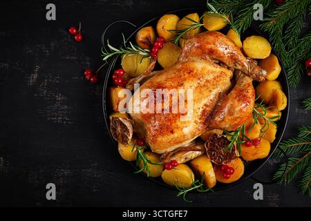 Baked chicken or turkey. Roasted chicken with potatoes and Christmas decoration.  Table setting. Top view, closeup Stock Photo