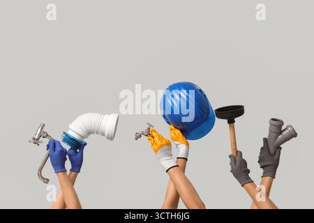 Hands with hardhat and plumber supplies on grey background Stock Photo