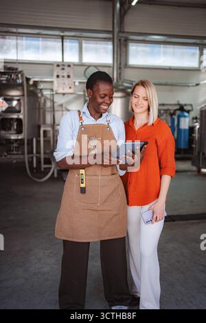 Diverse brewery owners using tablet for quality control inspection Stock Photo