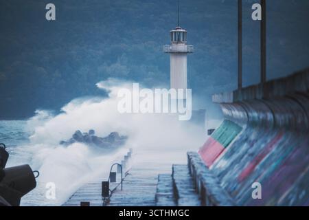 Stormy Huge Waves Breaks Against Sea Port Pier and Lighthouse coast of Varna City Bulgaria Stock Photo