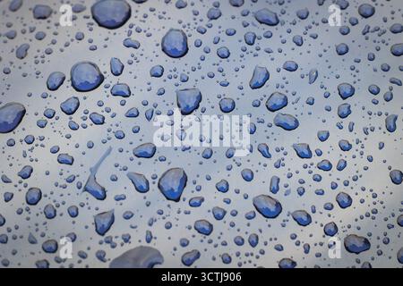 Close up on a rain drops on a car body surface Stock Photo
