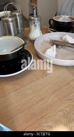 Empty coffee cups and dirty plates on a wooden cafe table after a meal. Mobile photo Stock Photo