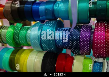 Multi-colored ribbons on a store shelf. Sewing and handicrafts Stock Photo