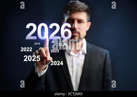 Man interacting with futuristic display showing years from 2019 to 2026 Stock Photo