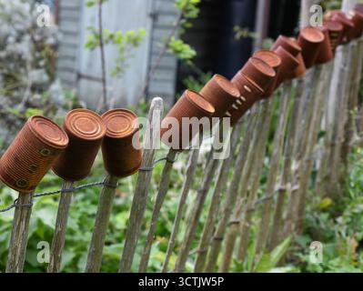 Tin cans along a picket fence Stock Photo
