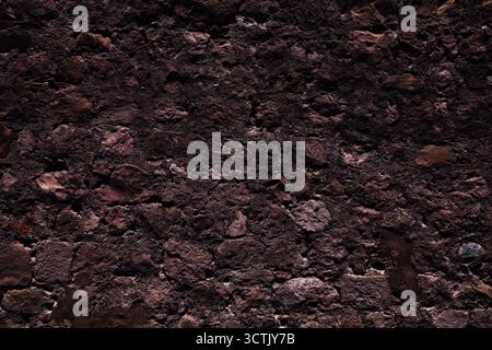 Grungy dark background stone wall. Weathered grunge old wall texture. Stock Photo