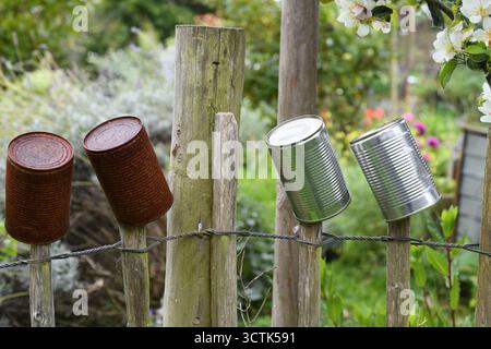 Tin cans along a picket fence Stock Photo