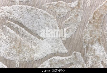 Close up of beige plush textile with decorative embossed pattern, detailed texture of soft fabric material for background, upholstery or home interior Stock Photo