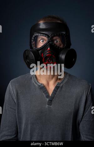 Halloween mask. A man wears a scary clown mask and a black hooded polo ...
