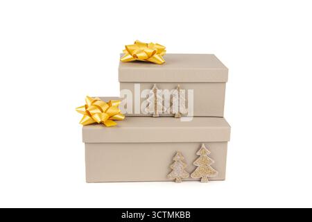 Christmas beige gift boxes with yellow ribbons, fir-tree decorations on white background. Two Christmas gift boxes stack on white. Stock Photo