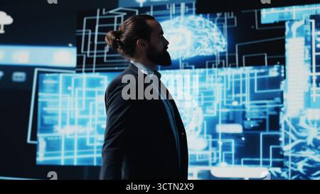 Company leader interacting with a digital AI brain symbolizing web platforms, using machine learning and algorithm development for intelligent innovation and future tech strategy. Camera A. Stock Photo