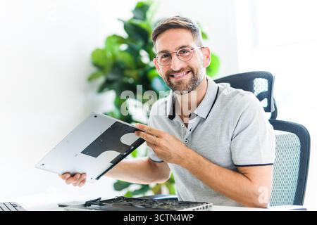 Handsome engineer repairing laptop computer. Stock Photo