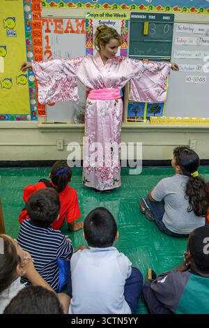 Miami Florida,Frederick Douglass Elementary School teacher dressed,literary costume oriental fictional character students boys girls listening storyte Stock Photo