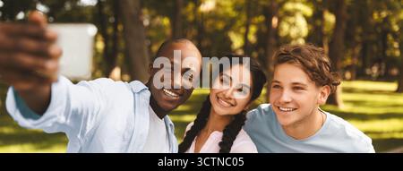 Capturing moments. Cheerful african american student guy taking selfie with his university friends in campus Stock Photo