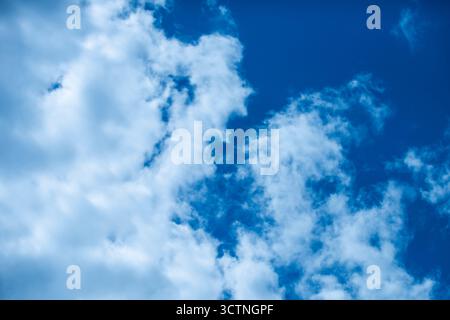 Sky view. Sky is blue and clear with clouds. Sun is shining brightly. Peaceful scene. Sun shining through the puffy clouds. Beautiful sunny sky Stock Photo