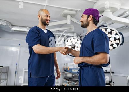 Surgeons Handshake in Operating Room Stock Photo