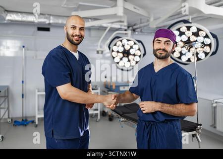 Surgeons Handshake in Operating Room Stock Photo