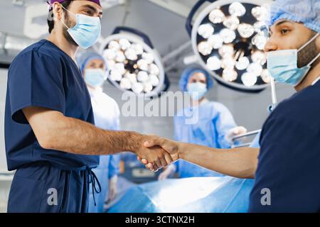 Surgeons Handshake in Operating Room Stock Photo