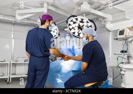 Surgeons Handshake in Operating Room Stock Photo
