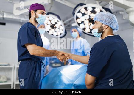 Surgeons Handshake in Operating Room Stock Photo