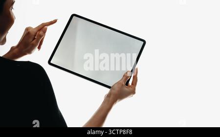 Person holding and interacting with a blank digital tablet screen, isolated on a white background, highlighting technology, touch interaction, and min Stock Photo