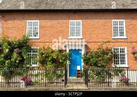 Old red brick building with roses growing on the front Bishop's Castle, Shropshire, England Stock Photo
