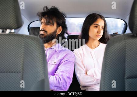 Indian couple sitting in silence in car, looking away from each other Stock Photo