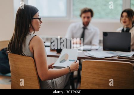 Team members discussing project details during an office meeting Stock Photo