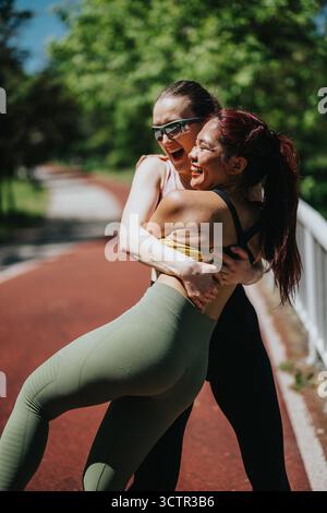 Two active women enjoying a fun moment during outdoor exercise together Stock Photo