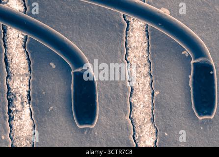Electron microscope view of a CPU fragment at 1000x magnification, revealing nanoscale structures and etched patterns in high detail. Stock Photo