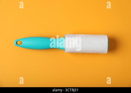One lint roller on orange background, top view Stock Photo