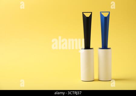 Two lint rollers on yellow background, space for text Stock Photo