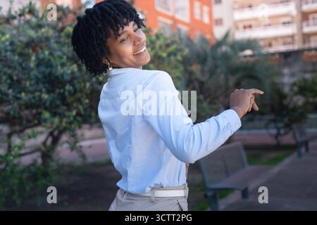 Beautiful, happy black woman with dreadlocks dancing in a park. Stock Photo