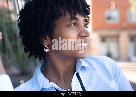 Young black woman with dreadlocks smiling outdoors Stock Photo