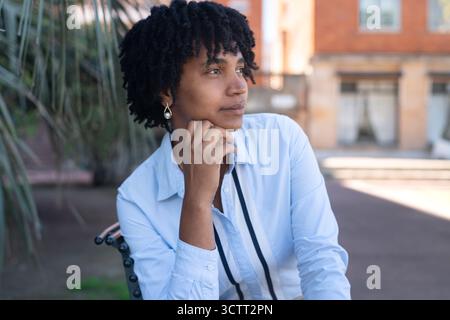 Thoughtful young black woman, outdoors in an urban setting. Stock Photo