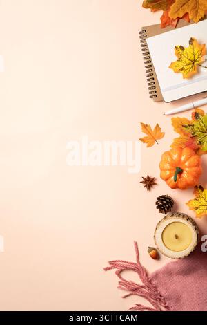 Autumn flat lay background. Autumn leaves, notepad, scarf, candle and spices on yellow background. Stock Photo
