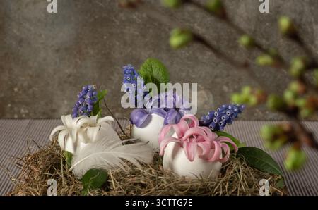 The eggshell is decorated with hyacinths and leaves in a hay nest. Zero waste, Blurred foreground and selective focus. Stock Photo